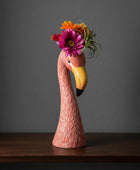 Flamingo figurine with a floral headpiece on a white background