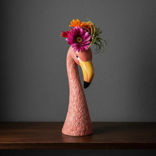 Flamingo figurine with a floral headpiece on a white background