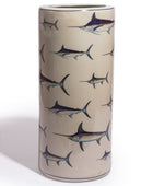 A tall cylindrical ceramic vase with a glossy finish, decorated with a repeating pattern of sailfish in dark blue-gray and silver-gray tones on a warm beige background.