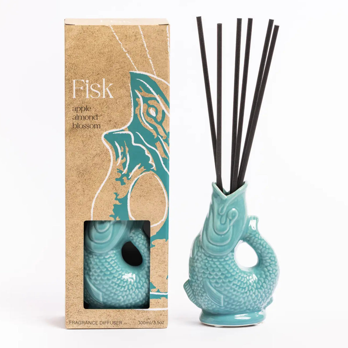 A reed diffuser set with a turquoise fish-shaped ceramic diffuser vase containing black reeds, shown next to its kraft paper packaging box labeled 'Fisk' on a white background.