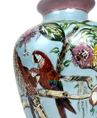Decorative vase with parrot and floral design on a light blue background