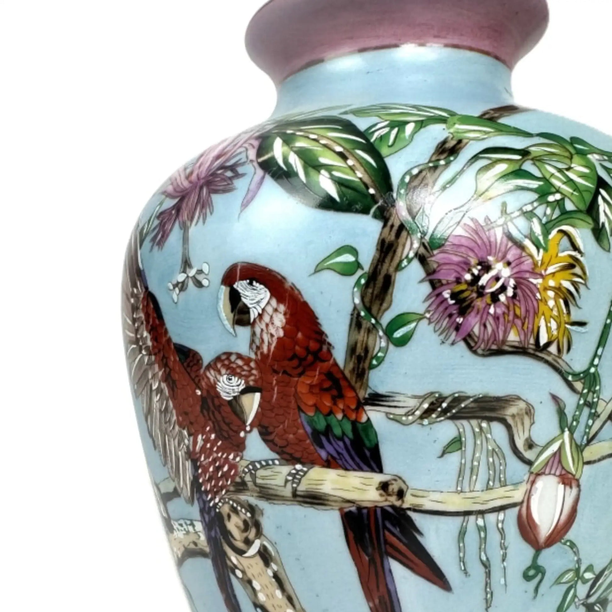 Decorative vase with parrot and floral design on a light blue background