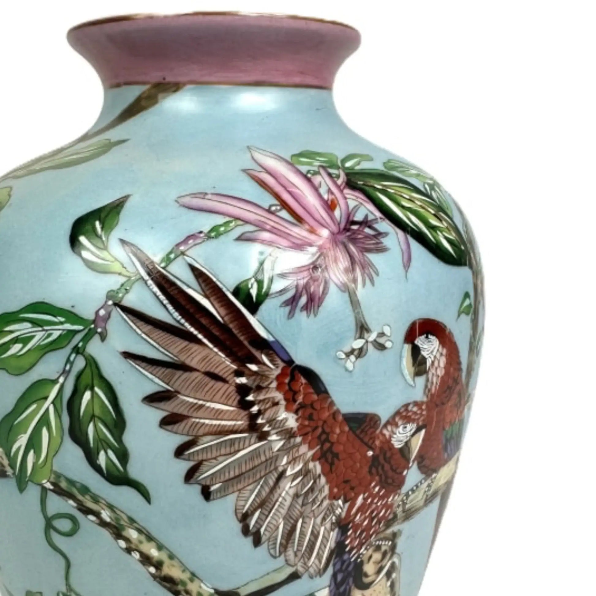 Ceramic vase with parrot and flower design on a light blue background