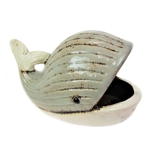 A ceramic whale-shaped container or dish with a glossy pale green-gray glaze, dark brown distressed lines, and a small black eye, shown on a plain white background.