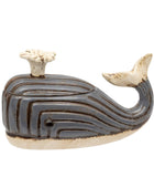 A whale-shaped ceramic container with a lid, featuring a dark brown and beige striped pattern with a cream-colored blowhole and tail.
