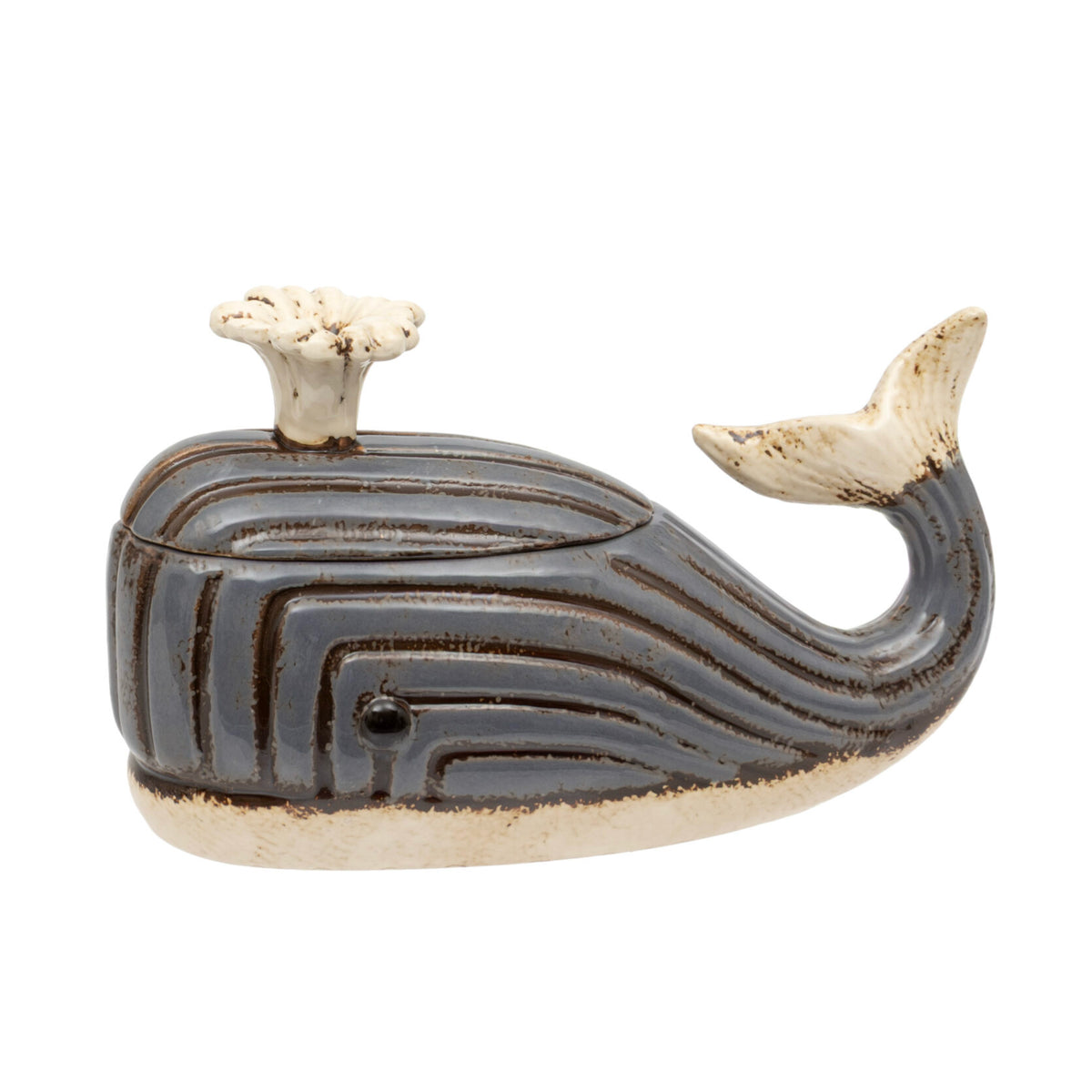 A whale-shaped ceramic container with a lid, featuring a dark brown and beige striped pattern with a cream-colored blowhole and tail.