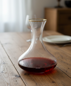 Clear glass decanter with red liquid on a wooden table