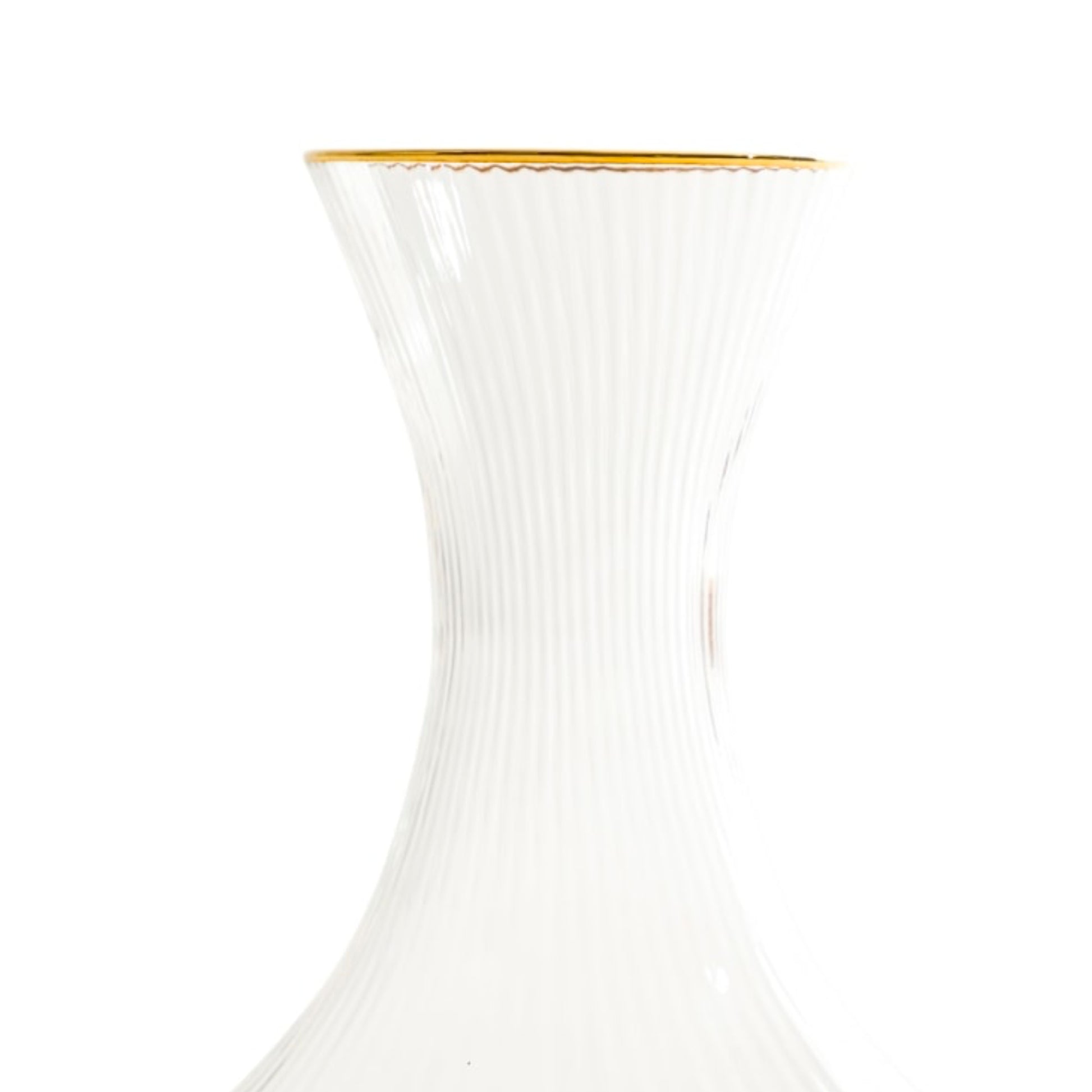 Clear glass carafe with gold rim on a white background