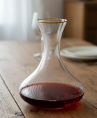 Clear glass wine decanter with red wine on a wooden table