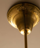 Close-up of a gold ceiling fixture against a beige wall.