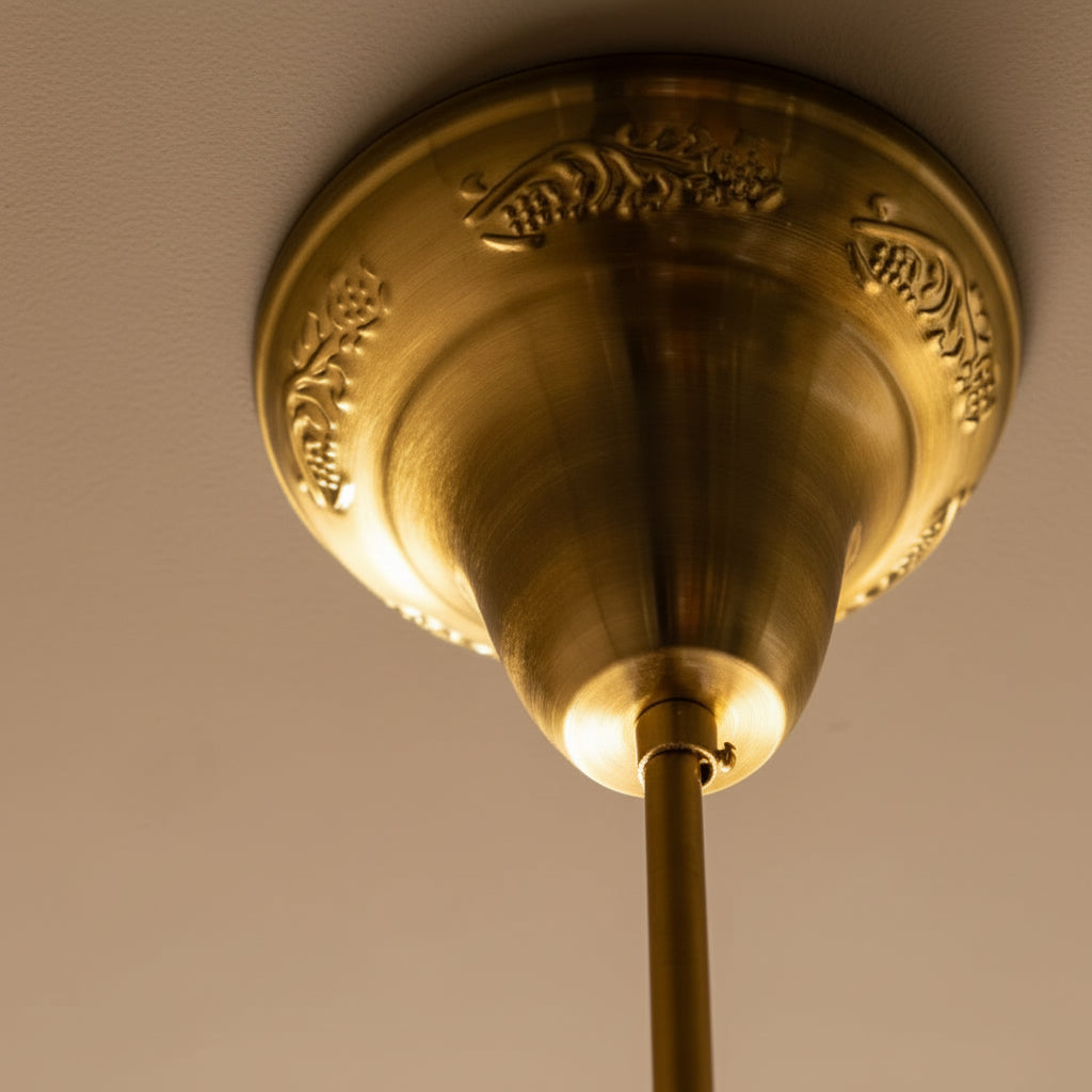 Close-up of a gold ceiling fixture against a beige wall.