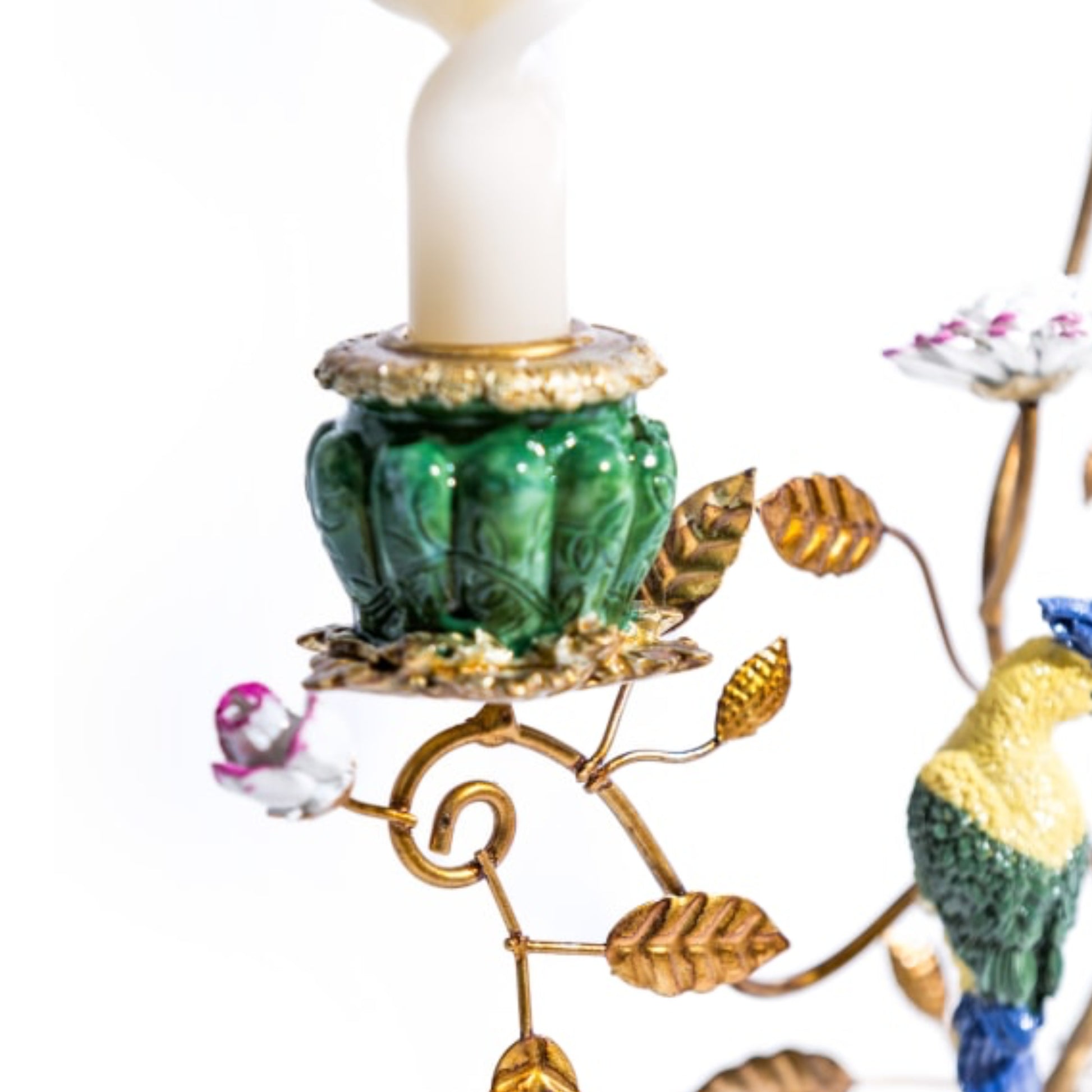 Decorative candle holder with birds and leaves on a white background