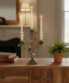 Decorative candle holder with candles on a wooden table in a room setting.