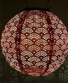 Decorative spherical lamp with intricate pattern on a dark background
