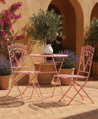 Pink outdoor furniture set with decorative elements on a patio.