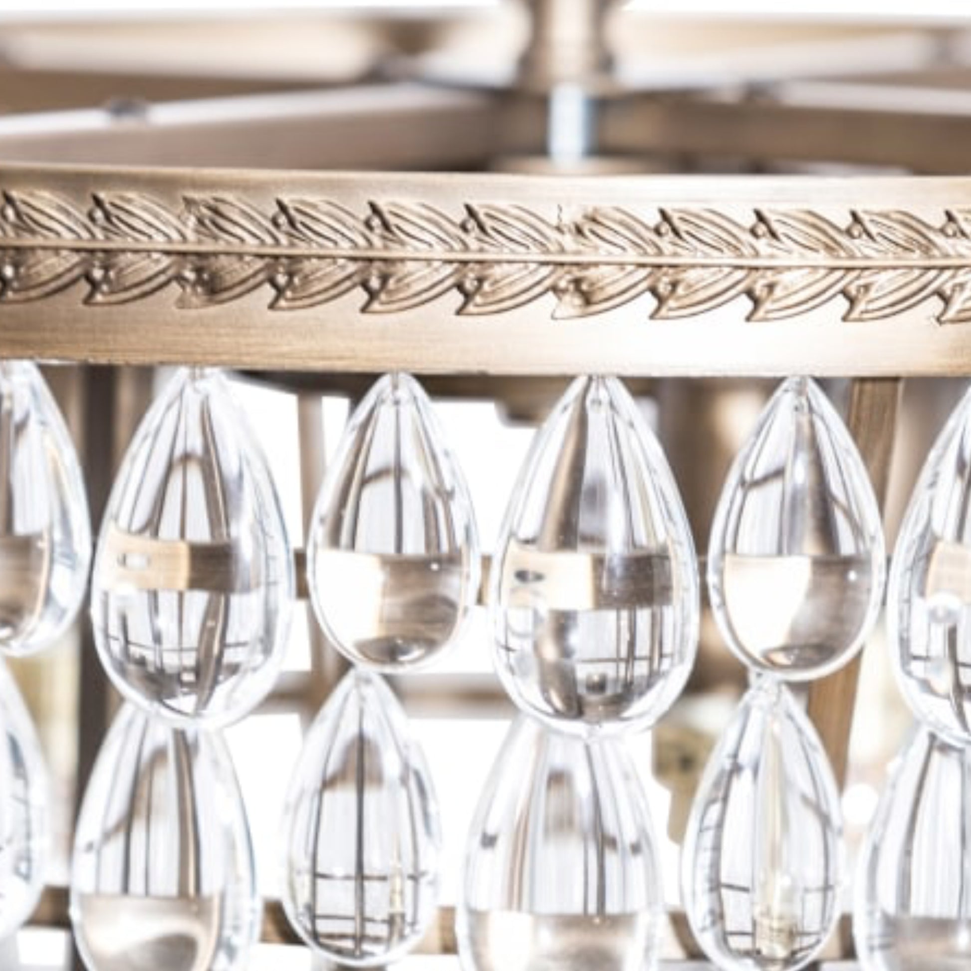 Decorative glassware hanging from a gold metal rack with intricate designs.