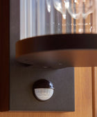 Motion sensor attached to a wall with a glass cover