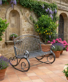 Decorative garden bench with potted plants in a stone-walled courtyard.