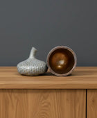 Decorative ceramic jar with textured lid on a wooden surface