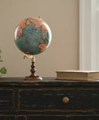 Vintage-style globe on a wooden dresser with a plant and book