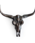 Metallic bull skull with long horns on a white background