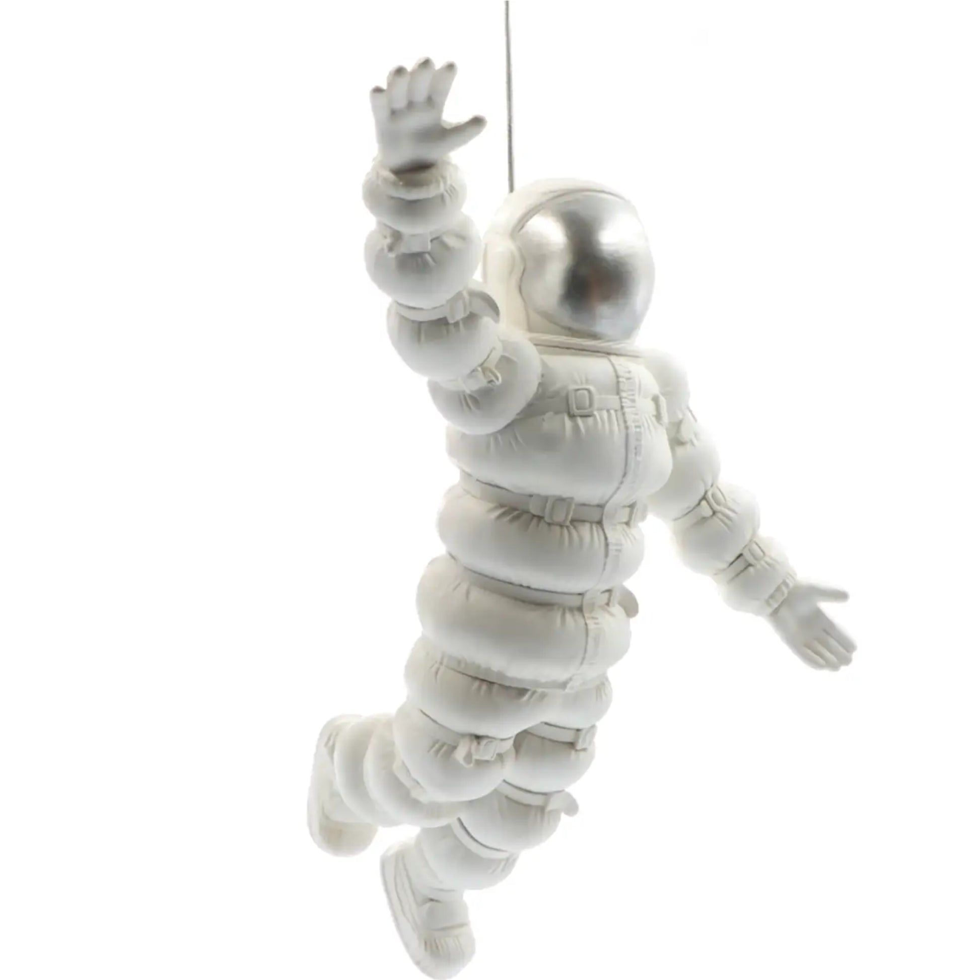 White astronaut figure hanging against a white background