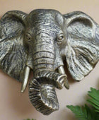 Bronze elephant head sculpture on a stone wall