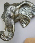 Bronze elephant head sculpture on a stone wall
