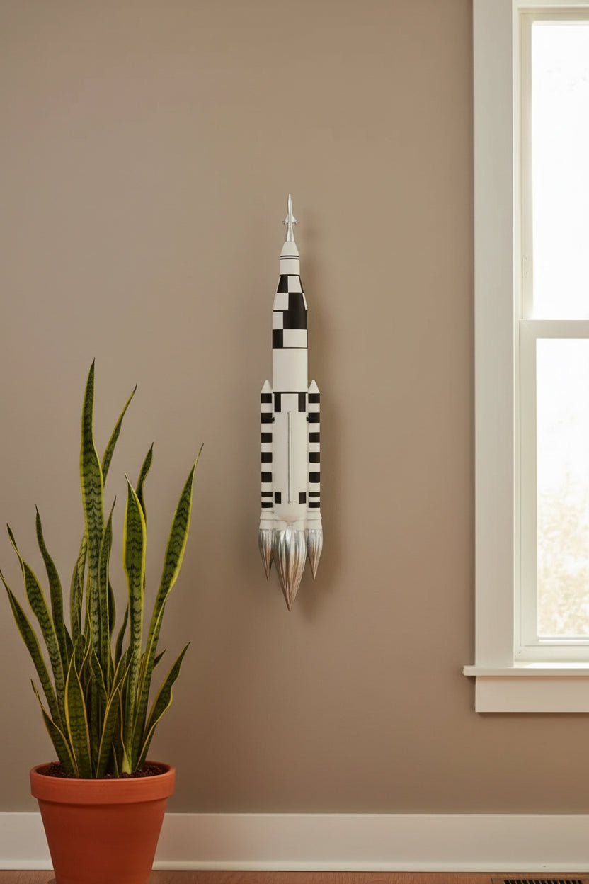 Wall-mounted model of a rocket with space-themed decor including NASA patches and astronaut figurines.