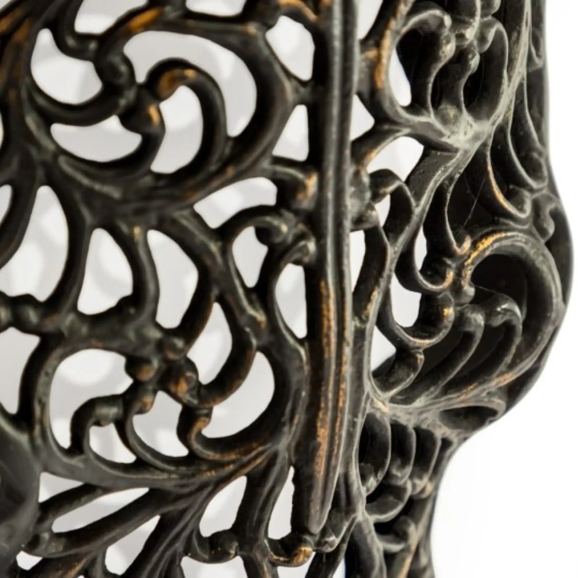 Close-up of a decorative metal stand with intricate patterns on a white background