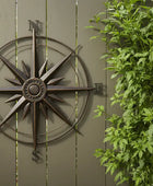 Decorative compass on a wooden wall with greenery