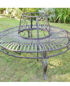 Round metal garden table with intricate designs on a grassy background