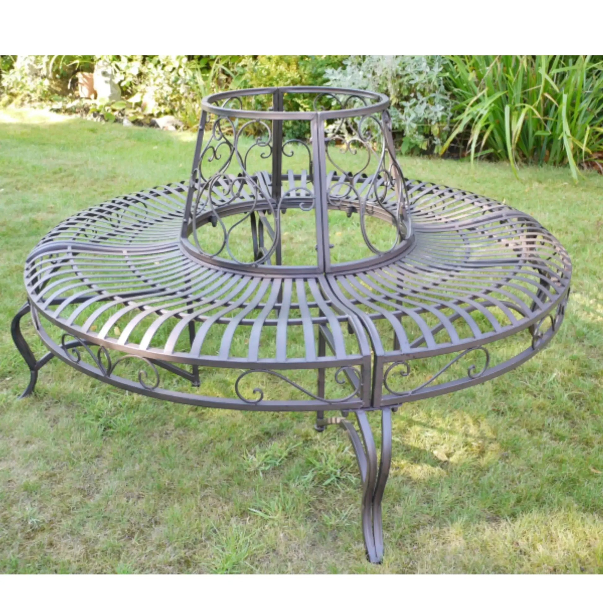 Round metal garden table with intricate designs on a grassy background