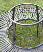 Decorative metal bench with intricate designs on a grassy background