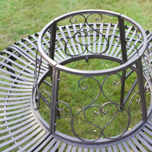 Decorative metal bench with intricate designs on a grassy background
