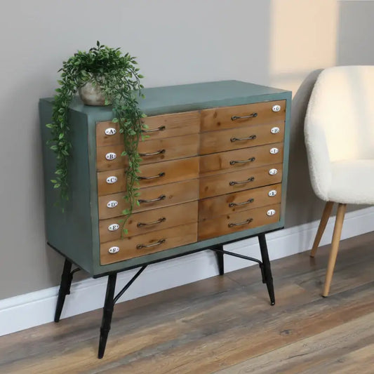 Wooden dresser with green top and black legs in a room setting.