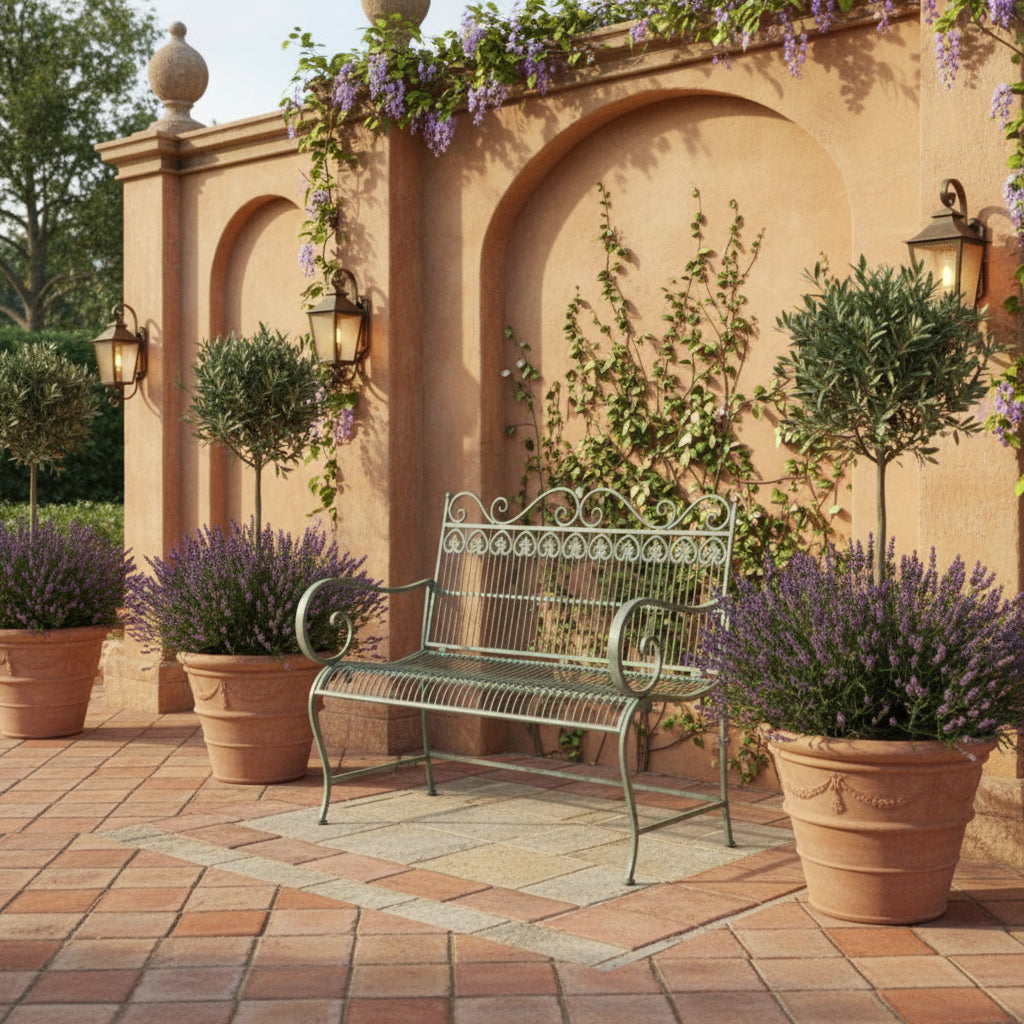 Wrought iron garden bench on grass with a fountain in the background
