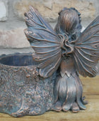 Bronze fairy figurine with butterfly wings on a stone surface