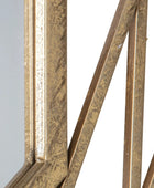 Close-up of a decorative metal frame with intricate patterns on a light gray background