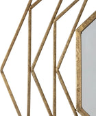 Decorative wall mirror with geometric gold frame on a white background