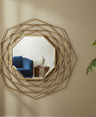 Decorative wall mirror with geometric gold frame on a beige wall