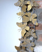 Decorative metal wall art with butterfly designs on a stone wall background