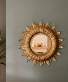 Decorative sun-shaped mirror on a plain wall