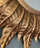 Close-up of a decorative gold leaf design on a plain background