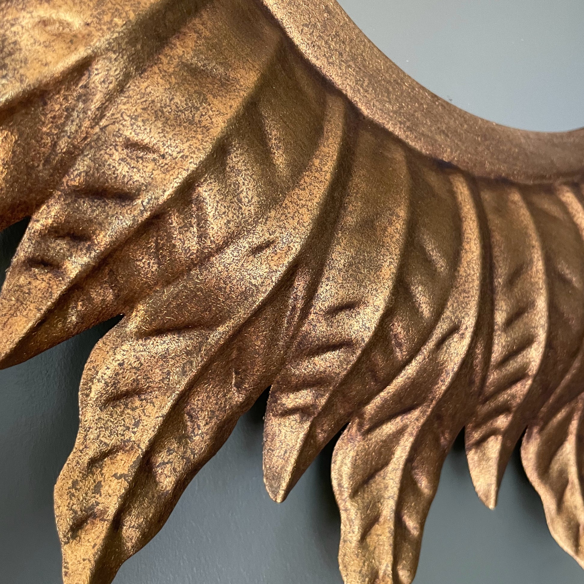 Close-up of a decorative gold leaf design on a plain background