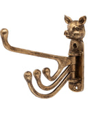 An antique bronze pig-shaped wall hook rack with a long curved hook and three smaller hooks, shown against a plain white background.