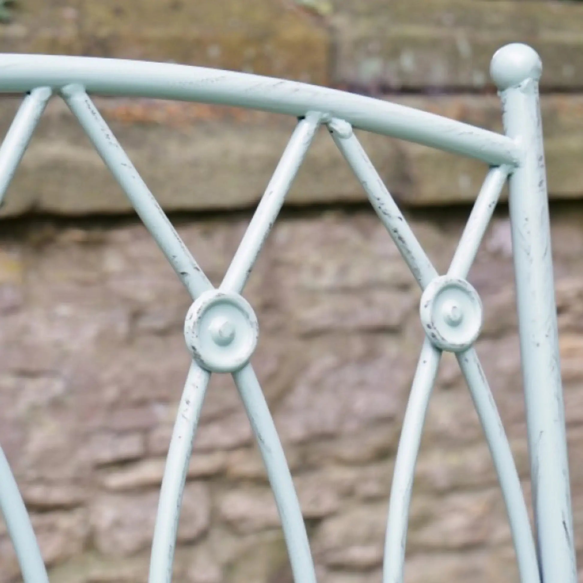 Metallic decorative railing with a stone wall background