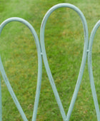 Metallic garden archway with a blurred green grass background