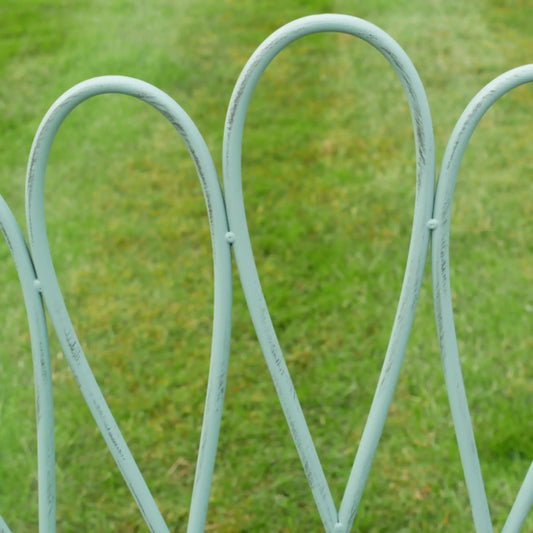 Metallic garden archway with a blurred green grass background
