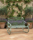 Decorative metal bench in a garden setting with potted plants and a stone wall.